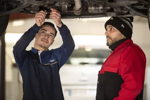Un jeune en train de réparer une voiture